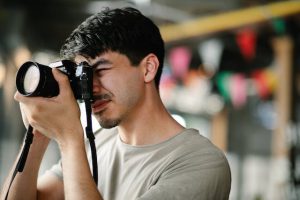 fotograf z aparatem w rękach robiący zdjęcie